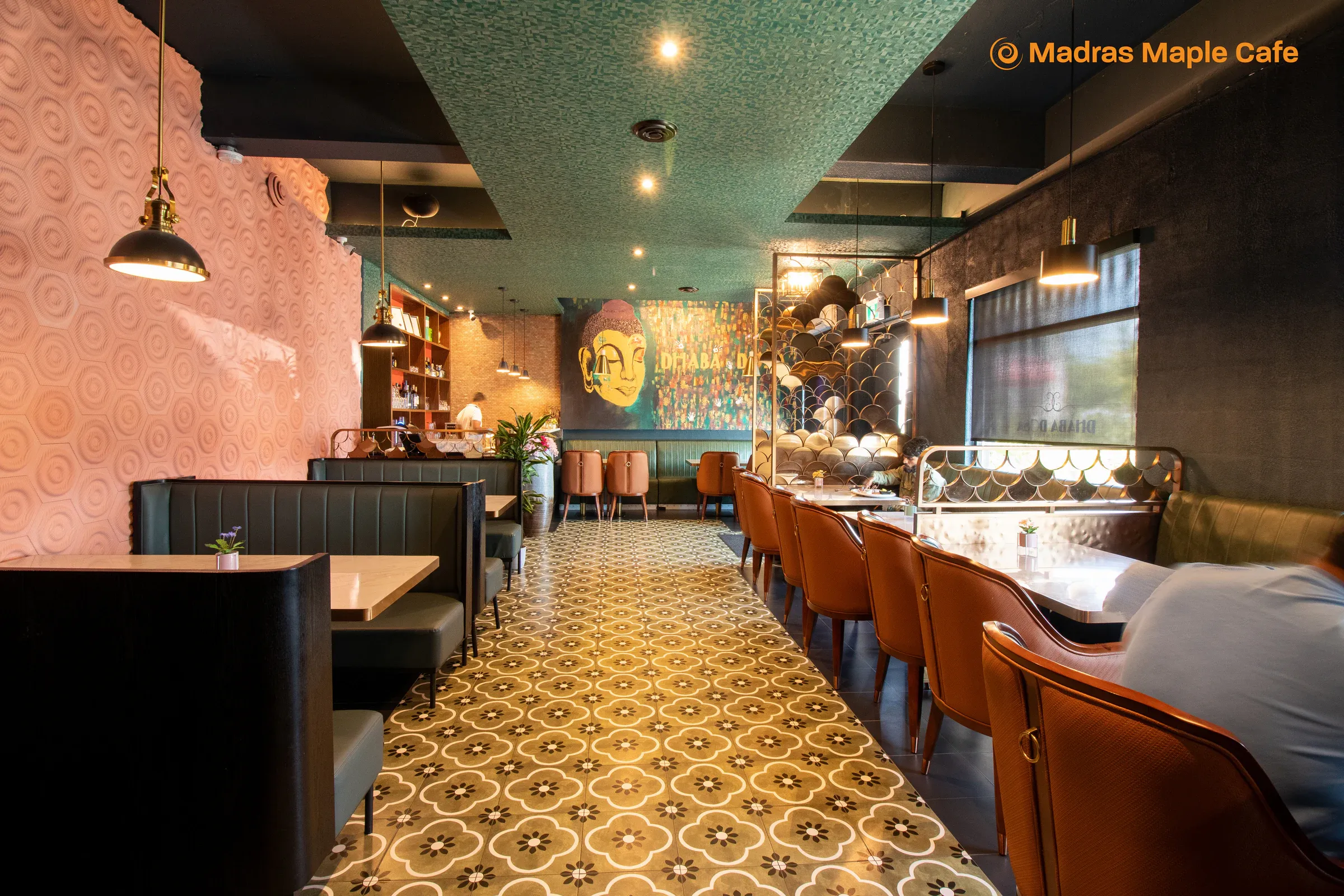 The Madras Maple Cafe dining room with booths, tables, and warm pendant lighting
