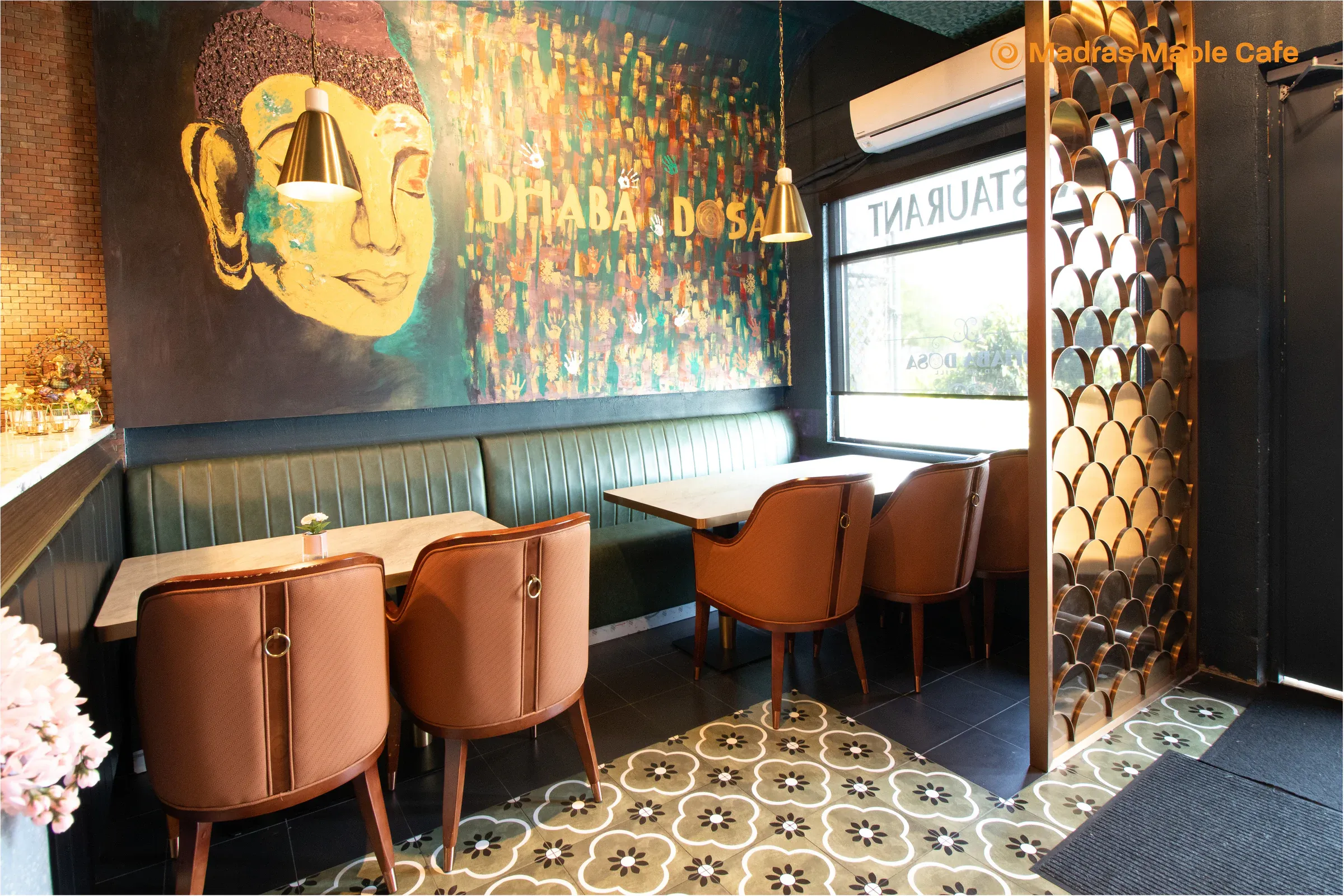 Madras Maple Cafe seating beside colorful restaurant wall art