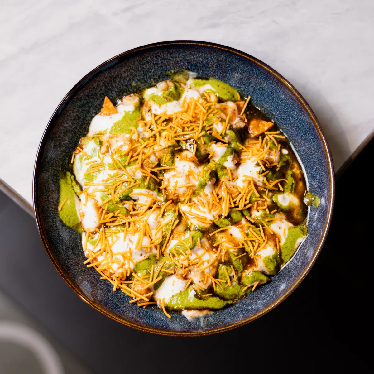 Crisp flour papdi layered with potato, chickpeas, yogurt, and tangy chutneys.